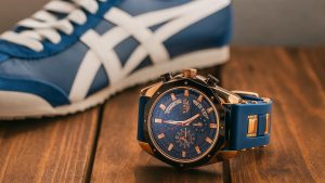 Watch and shoe combinations placed on a wooden platform focused on same blue color